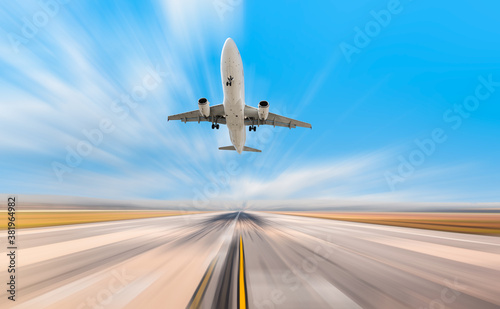 Airplane in motion- White Passenger plane fly up over take-off runway from airport 