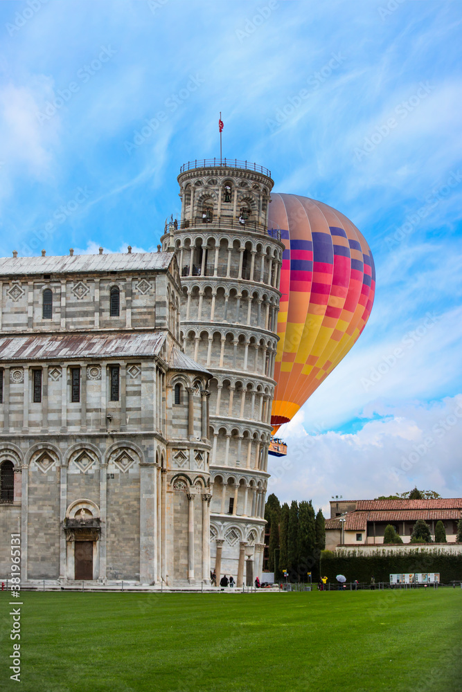 Hot air balloon flying over Pisa, Piazza dei miracoli, with the Basilica and the leaning tower - Italy