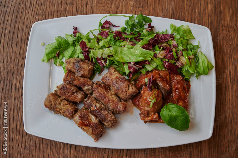 Grilled meat with green vegetables on wooden table Grilled meat with green vegetables on wooden table