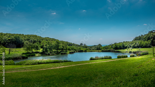 Panorama of Ljeskove vode lake. Green forest and blue sky in the background. Picnic area near Slavonski Brod, Croatia. © The Walker