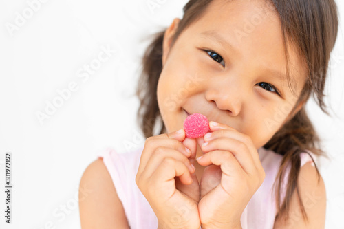 A happy kid holding a gummy candy. Children vitamin.