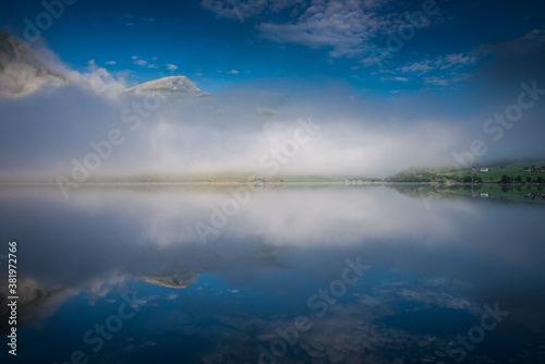 morning fog over the lake. Beautiful nature of Norway, fishing boats on the river
