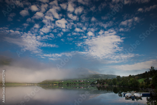 morning fog over the lake. Beautiful nature of Norway, fishing boats on the river