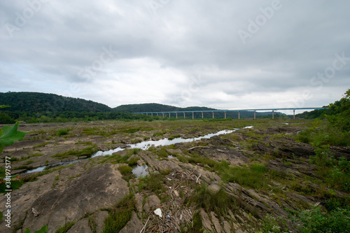 A Sprawling Landscape Covered in Rock Formations and Plants With the Norman Wood Bridge in the Background