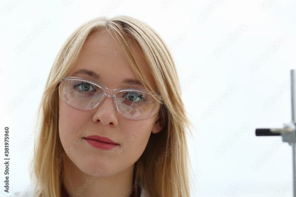Smiling beautiful technician woman portrait and sample bottle with poison fluid. Medical worker in uniform use reagent tube for virus infection exam or biological toxic reaction, drug creation Smiling beautiful technician woman portrait and sample bottle with poison fluid. Medical worker in uniform use reagent tube for virus infection exam or biological toxic reaction, drug creation