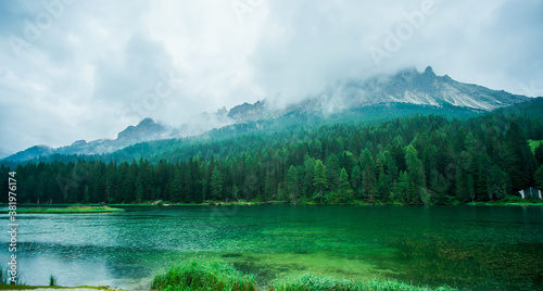 Canvas Print A rainy and foggy day by the green lake and mountains