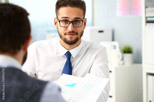 Group of businessmen with financial graph and silver pen in arm solve and discuss problem with colleague portrait. Situation examination at board council sale adviser job stock exchange market profit