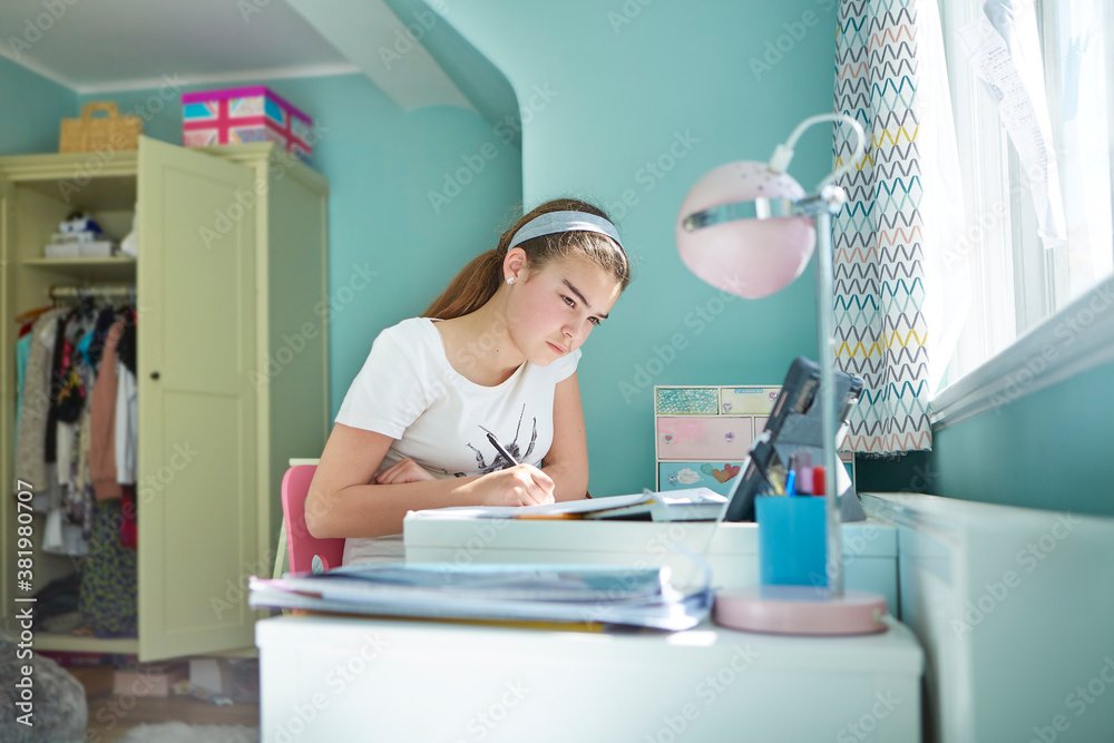 Focused girl homeschooling in bedroom Focused girl homeschooling in bedroom