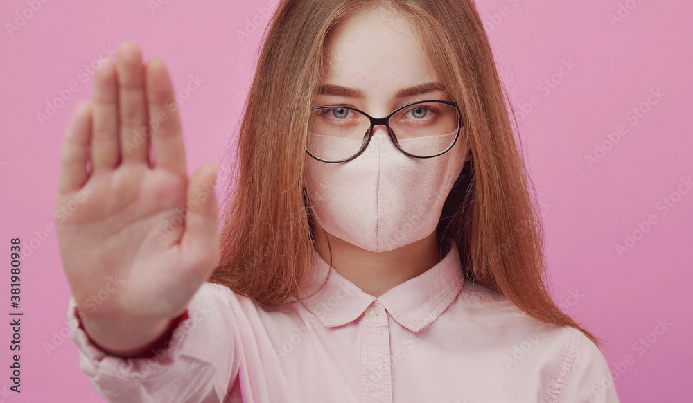 Headshot of young lady in protective facemask showing palm with stop sign, social distancing concept Headshot of young lady in protective facemask showing palm with stop sign, social distancing concept