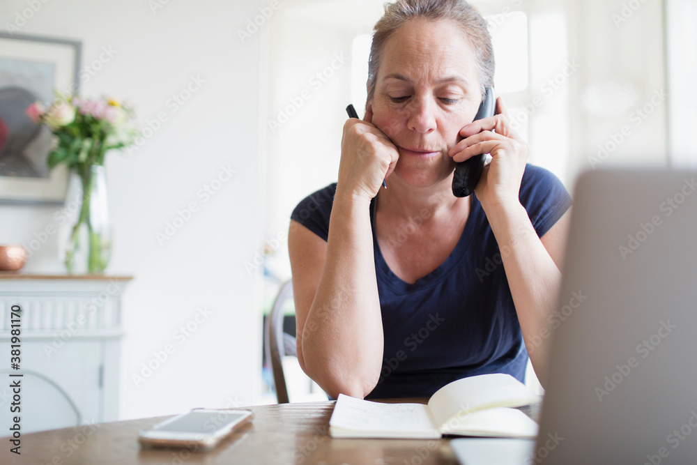 Woman working from home talking on telephone Woman working from home talking on telephone