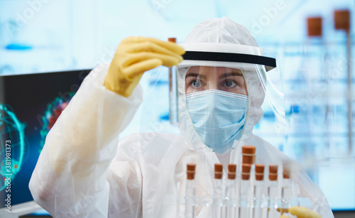 Female scientist in clean suit researching coronavirus vaccine photo