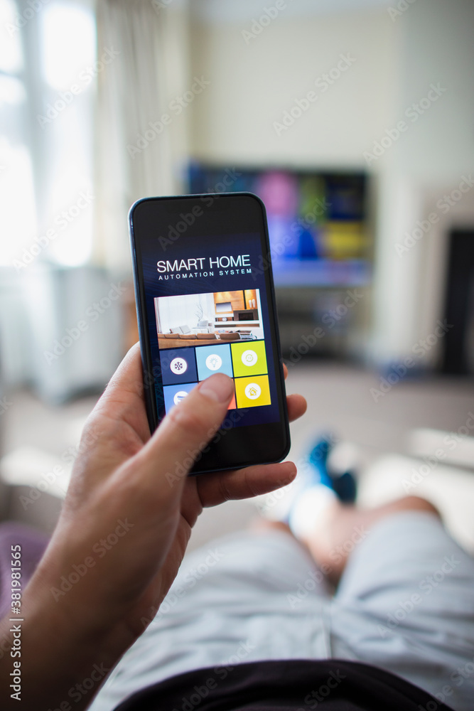 POV Man using home automation on smart phone in living room POV Man using home automation on smart phone in living room