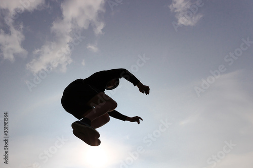 The guy is engaged in parkour jumping against the sky