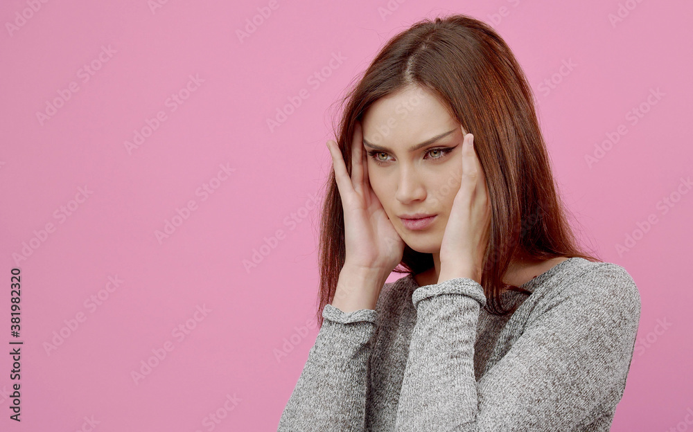 Young woman suffering from headache touching head massaging temples isolated on pink, half-turn view Young woman suffering from headache touching head massaging temples isolated on pink, half-turn view