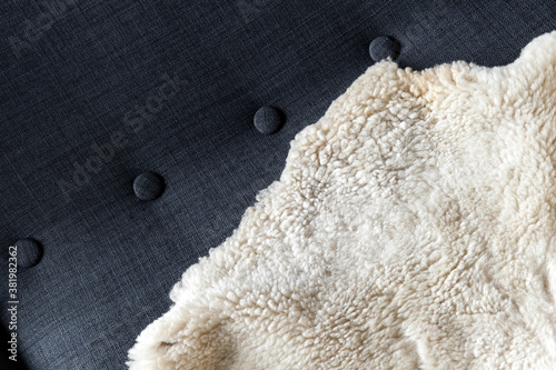 Bilde på lerret Natural white sheepskin covers dark gray sofa