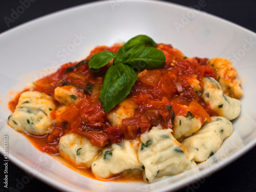 Herb gnocchi with tomato sauce and basil