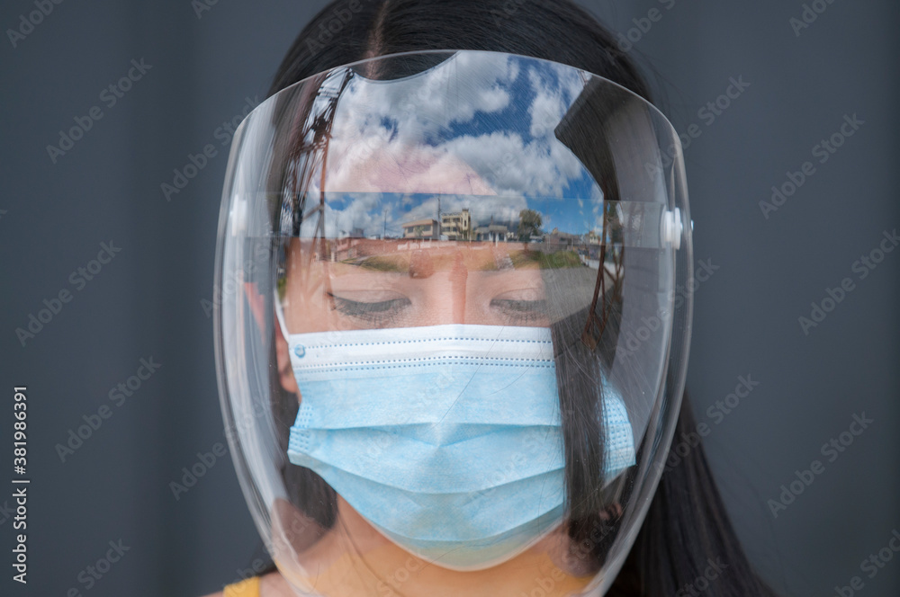 close up latin girl's face with surgical mask and face shield,  visor and mask as a safety precaution against coronavirus