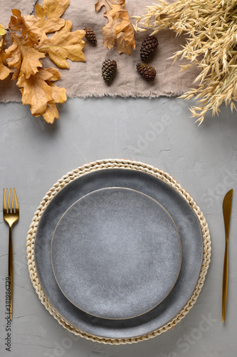 Autumn festive table setting with fall golden decor on grey table. Flat lay. View from above. Vertical. Thankisgiving day.