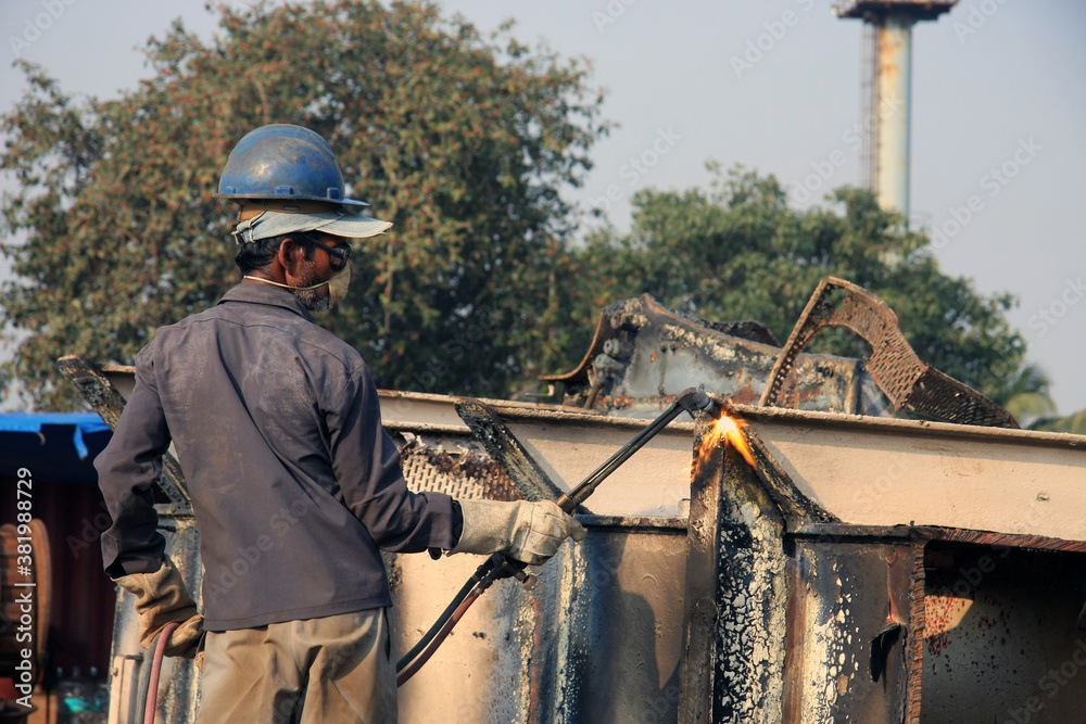 Shipbreaking Yard in Darukhana, Mumbai, India – INS Vikrant dismantling with scrap metal & workers in background Shipbreaking Yard in Darukhana, Mumbai, India – INS Vikrant dismantling with scrap metal & workers in background