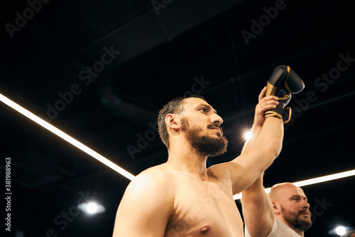 Bearded boxer getting his arm raised by referee photo