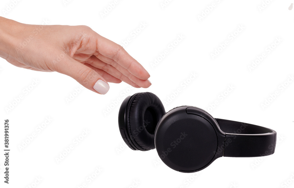 Hand with Wireless black headphones. Isolated on white background. Hand with Wireless black headphones. Isolated on white background.