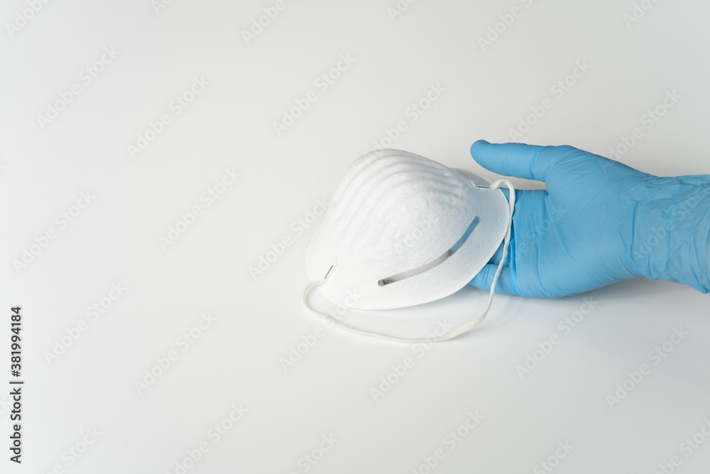 COVID, COVID-19 PPE Blue Latex Glove on Lady's Hand, Holding White Mask, On White Background COVID, COVID-19 PPE Blue Latex Glove on Lady's Hand, Holding White Mask, On White Background