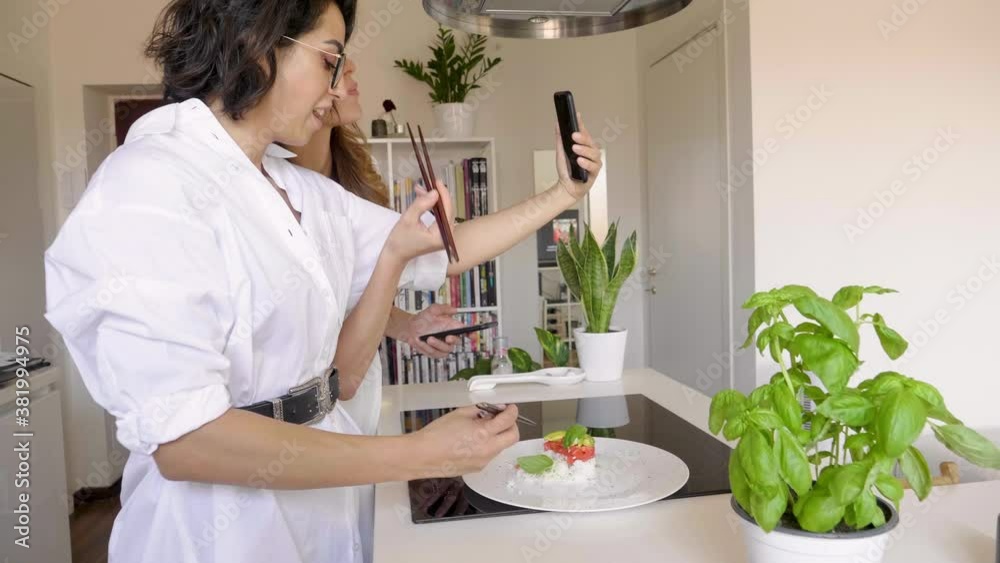 Two women eating with sushi chopsticks and having Two women eating with sushi chopsticks and having