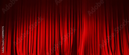 Foto Closed red curtain of stage in spotlight before show.