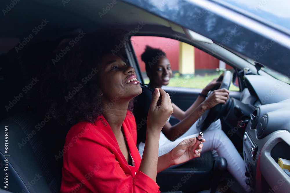 Beautiful girl adjusts makeup in the car, African-American woman