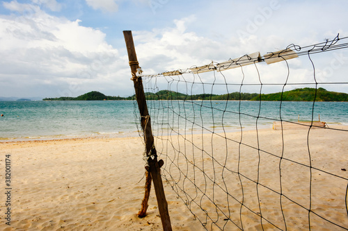 Beach volleyball net on the empty beach with the blue sea and sky. Copy space. 
