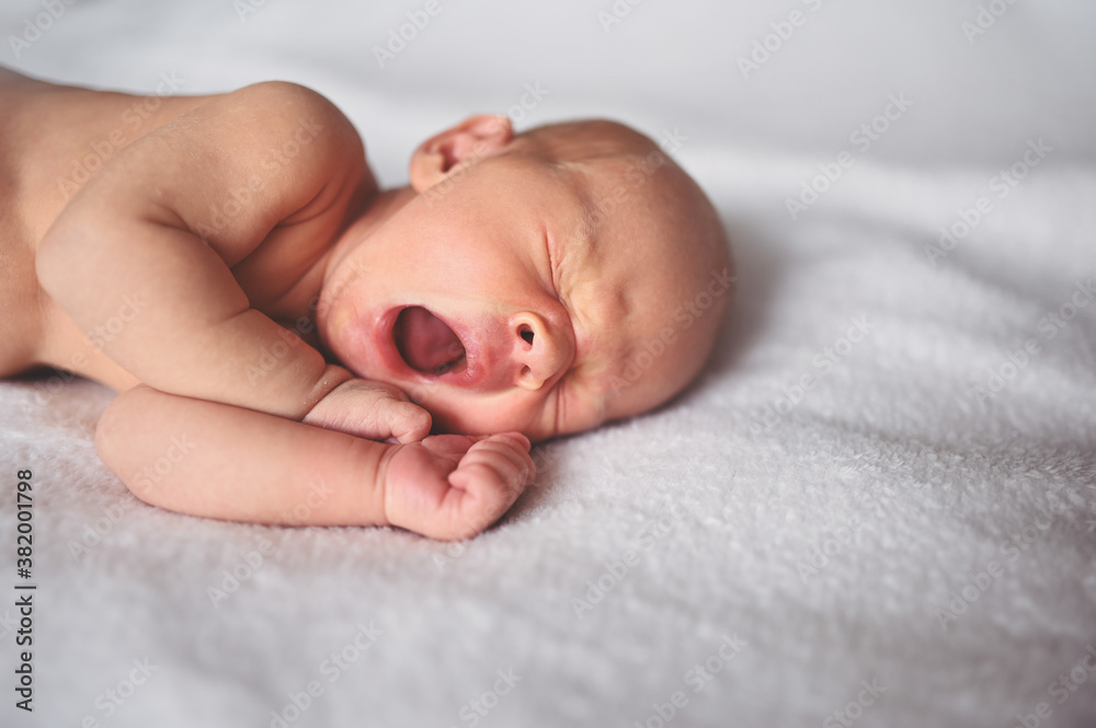 Cute emotional newborn yawning funny little baby boy sleeping in crib. Baby goods packaging template. Healthy child, concept of hospital and happy motherhood. Infant baby. Nursery Cute emotional newborn yawning funny little baby boy sleeping in crib. Baby goods packaging template. Healthy child, concept of hospital and happy motherhood. Infant baby. Nursery
