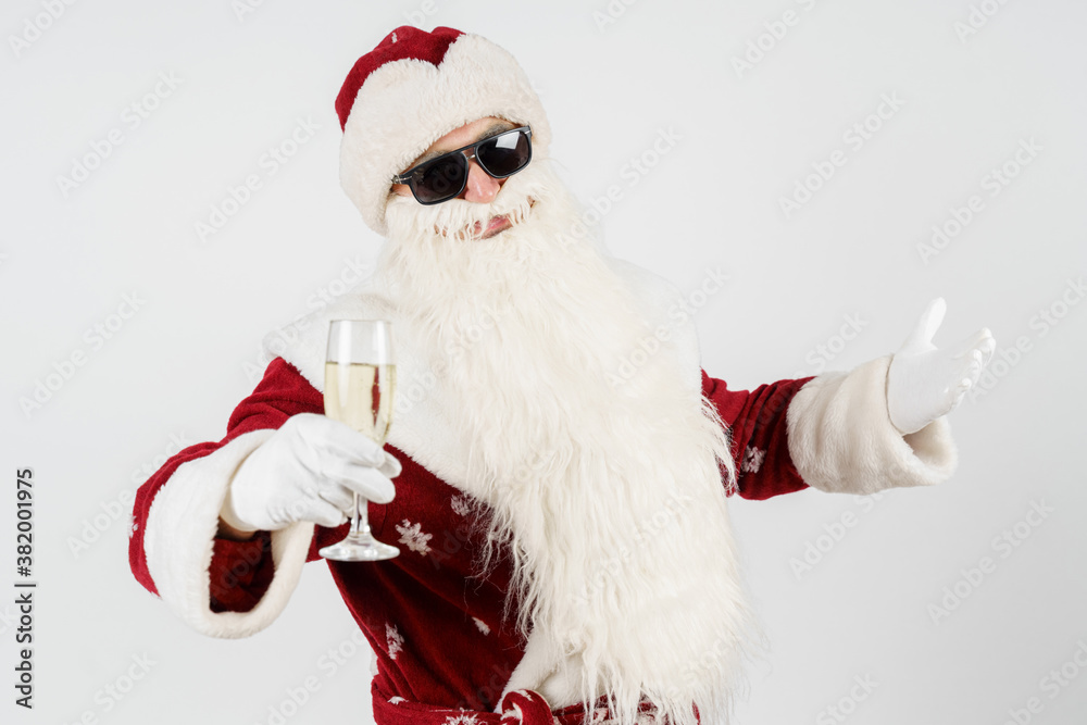 Santa Claus gestures with a glass in his hands. Isolated background.