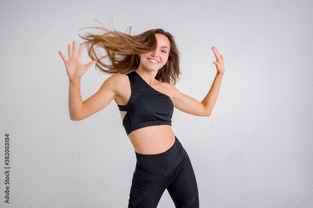 The brunette of an athletic physique goes in for sports in the studio on a white background.