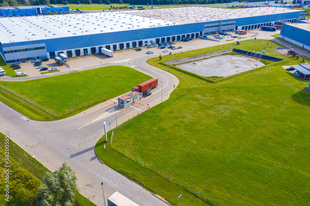 Naklejka premium Aerial Shot of Industrial Loading Area where Many Trucks Are Unloading Merchandise.