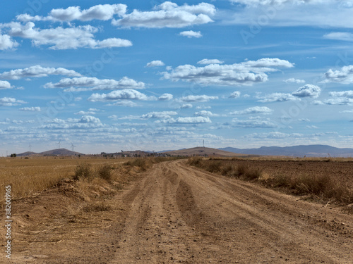 Country side view with empty road  blue sky and white cotton clouds