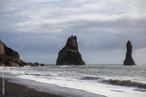 Reynisfjara black sand beach in sothern Iceland in Vik region, facing Reynisdrangar basalt rock formation.