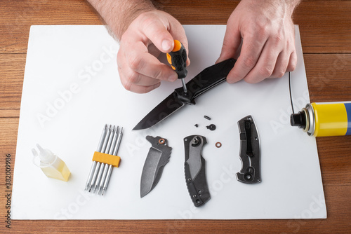 Man assembling a folding knife with a screwdriver