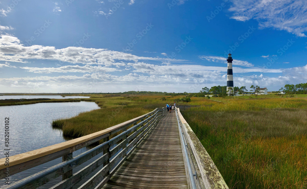 A wooden walkway leading up to a light house