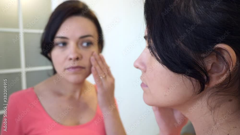 Young Woman Looks in Mirror at her Face and Hair with Disappointed Emotion. 2x Slow motion 60 fps 4K Young Woman Looks in Mirror at her Face and Hair with Disappointed Emotion. 2x Slow motion 60 fps 4K