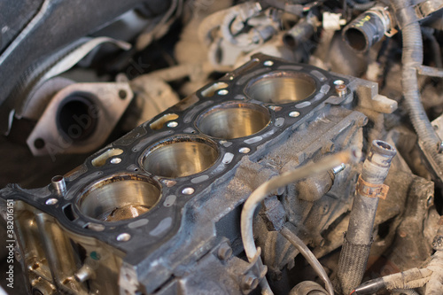 a close-up of an exploded car engine with the cylinder head removed. Soft focus, selective focus, horizontal photo. Idea - ICE repair, engine overhaul