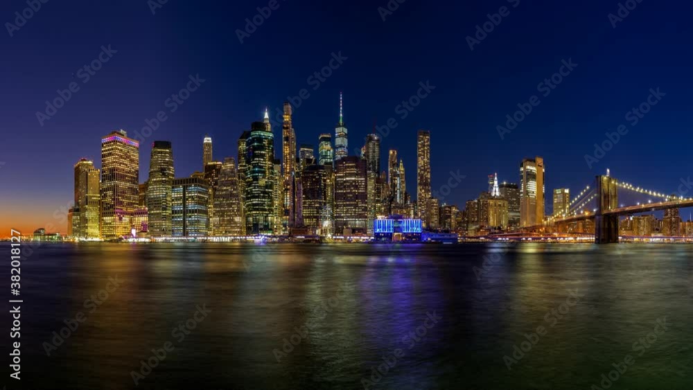 Panoramic image of lower Manhattan and the Brooklyn Bridge at night with the Hudson river reflecting the lights. Panoramic image of lower Manhattan and the Brooklyn Bridge at night with the Hudson river reflecting the lights.
