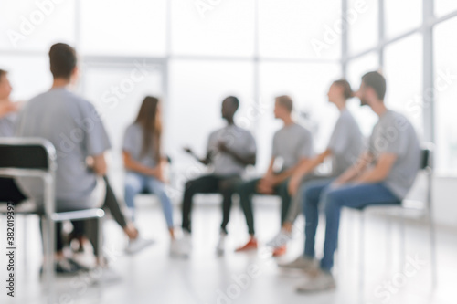 background image of a group of young people at a meeting in a conference room