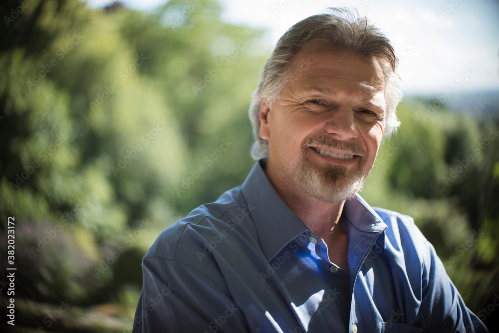 Portrait confident senior man on sunny patio Portrait confident senior man on sunny patio