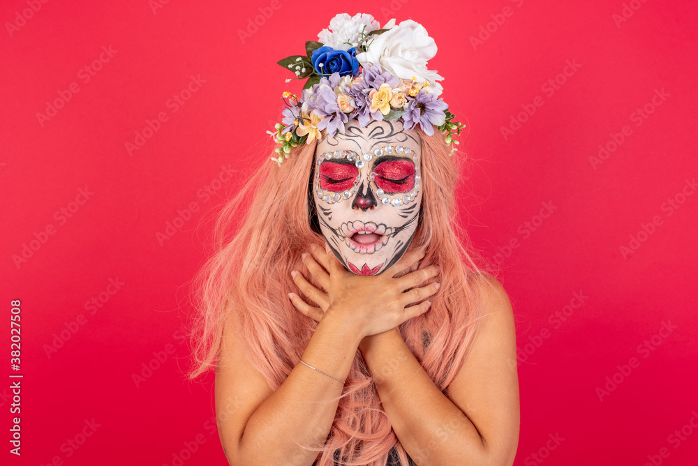 young beautiful woman wearing halloween make up over red background shouting suffocate because painful strangle. Health problem. Asphyxiate and suicide concept.