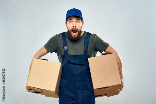 Man in working uniform with boxes in hands delivery loading lifestyle © SHOTPRIME STUDIO