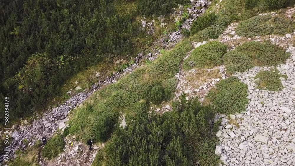Aerial view overlooking hikers, climbing up a steep mountain trail, sunny, autumn day, in Bulgaria - tracking, drone shot Aerial view overlooking hikers, climbing up a steep mountain trail, sunny, autumn day, in Bulgaria - tracking, drone shot