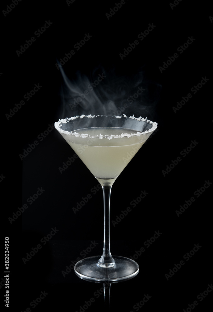 margarita cocktail with salty rim and smoke on the black background margarita cocktail with salty rim and smoke on the black background