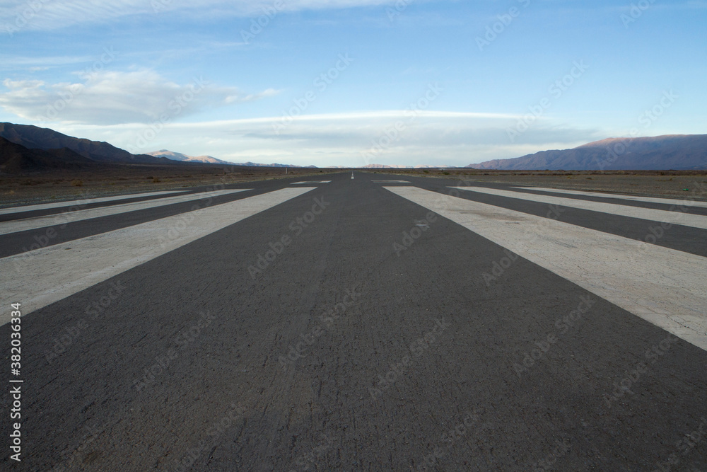Transport. Wide straight asphalt airdrome road across the desert and into the mountains. Transport. Wide straight asphalt airdrome road across the desert and into the mountains.