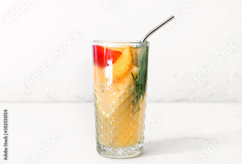 Glass of fresh peach lemonade on table