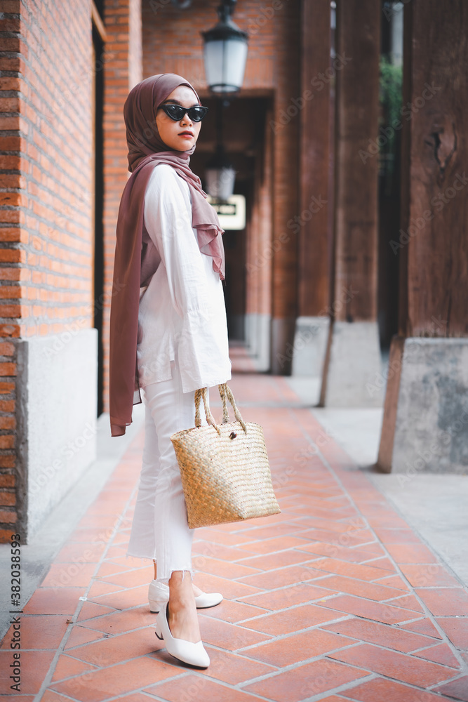 Fashion portrait hipster model muslim woman wering brown hijab and